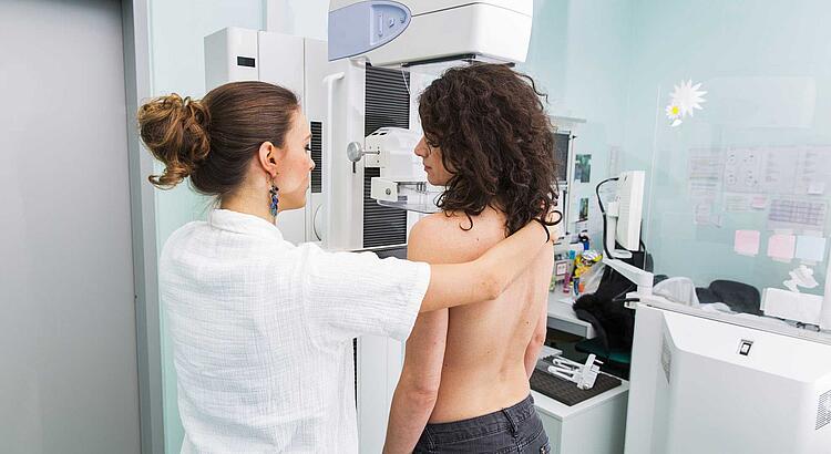 Krankenschwester macht ein Mammographie-Screening bei einer jungen Frau.